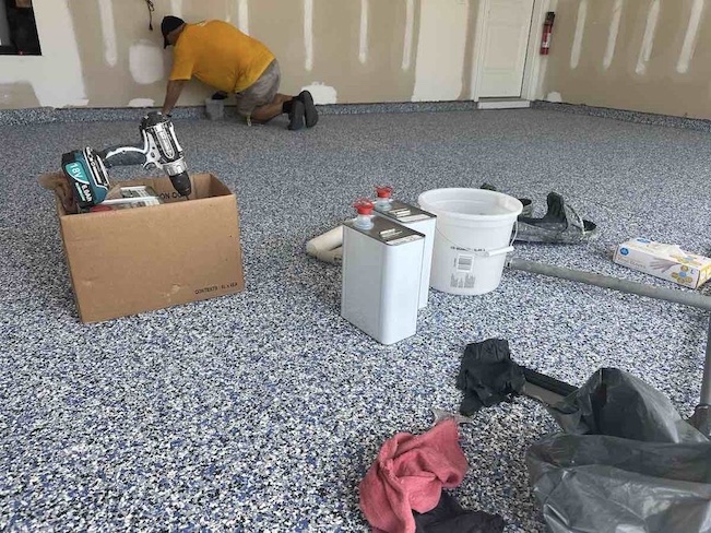 Tonny Fonseca, owner of Custom Garage Coatings, applying epoxy floor coating